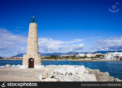 Stone lighthouse at the end of pier in Puerto Banus in Spain, southern Andalusia, Malaga province.
