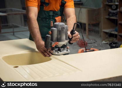 Stone sink furniture production. Carpenter polishes the surface of the sink with a grinder. Stone sink furniture production