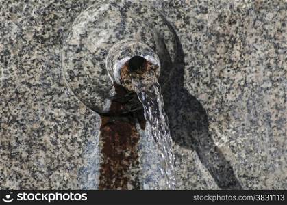 Stone spout of fountain with gushing thermal mineral water