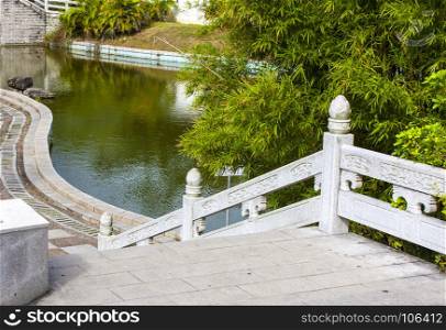 stone staircase with railing and walkway along the pond