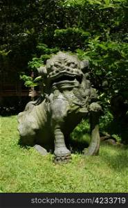 Stone statue of a lion in japanese garden. Japanese stone statue of a lion