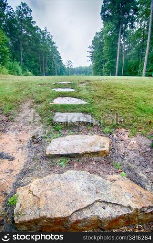 stone step stair leads to an open golf course