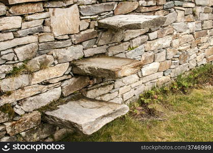 Stone steps into garden dry masonry stonewall closeup