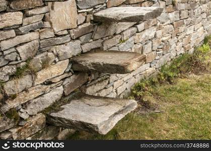 Stone steps into garden dry masonry stonewall closeup