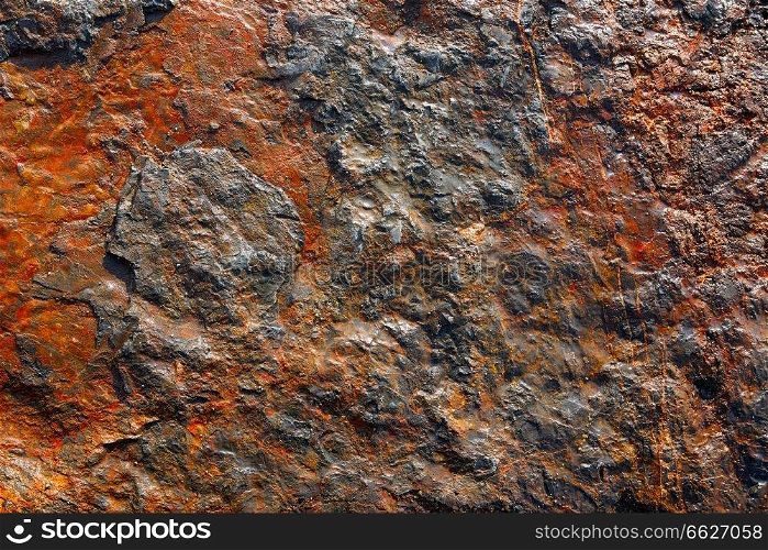Stone texture in the beach shore with red oxide