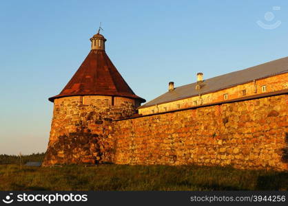 Stone tower and wall of the Solovetsky monastery on Solovki (Solovetsky archipelago), sunset. UNESCO World Heritage Site.