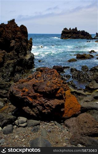 stone volcanic spain water coast in lanzarote sky cloud beach and summer &#xA;