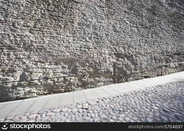 Stone wall and cobblestone street; Tallinn; Estonia; Europe