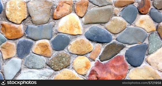 Stone wall of the house from different color of stones in a laying