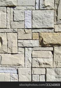 Stone wall with light brown, grey and beige natural stone