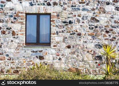 stone wall with window. particular of a stone house.