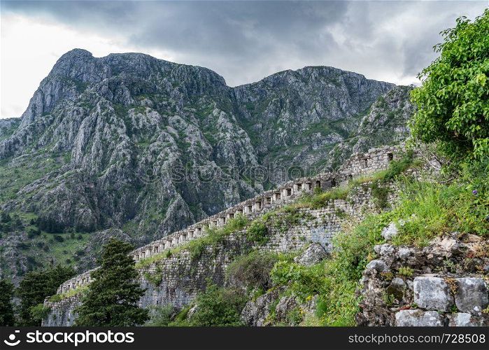 Stone walls of Kotor Fortress above the old town in Montenegro. Kotor Fortress on mountainside above old town in Montenegro