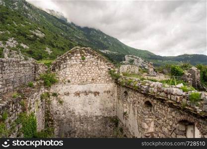 Stone walls of Kotor Fortress above the old town in Montenegro. Kotor Fortress on mountainside above old town in Montenegro