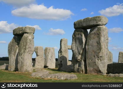 Stonehenge is a prehistoric monument located in the English county of Wiltshire, about 2 Miles west of Amesbury and 8 Miles north of Salisbury. One of the most famous sites in the world, Stonehenge is composed of earthworks surrounding a circular setting of large standing stones. It is at the centre of the most dense complex of Neolithic and Bronze Age monuments in England, including several hundred burial mounds. Archaeologists believed that the iconic stone monument was erected around 2500 BC.