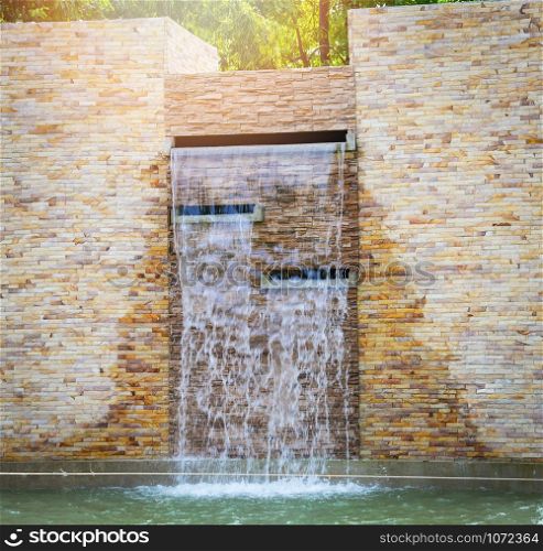 Stones brick and waterfall wall and water pond beautiful design decorate in the garden