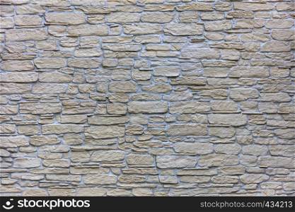 Stones from a sandstone, as a background from a stone wall. Abstract background of old stone cobblestone close-up.. Texture of a beige stone wall of a large cobbled stone close-up
