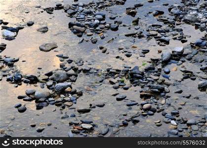 Stones on beach surrounded by water