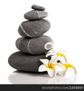 Stones pyramid with a plumeria flower, isolated on white background