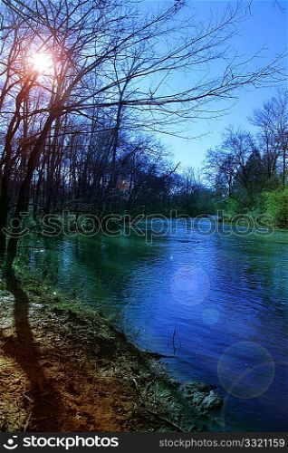Stones River Tennesee with water, trees, sun during winter.