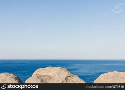 Stones, rocks, blue ocean water and sky horizon background. Nature abstract background. Stones, rocks, blue ocean water and sky horizon background.