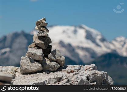 Stones Stacked One Onto Each Other and Mountain Ridge in Italian Dolomites Alps in Summer Time in Background