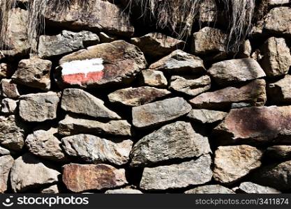 Stonewall with the sign of the mountain path, good for conceptual