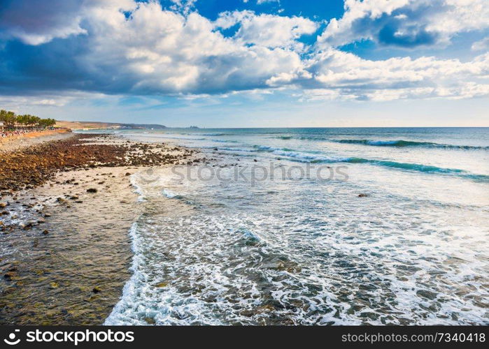 Stony coast and beach of Atlantic ocean at Maspalomas. Gran Canaria island, Spain