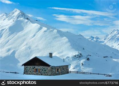 Stony house and ski track on winter mountain snowy slope (Tyrol, Austria). All people are unrecognizable.