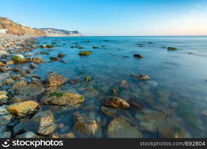 Stony sea beach of the 40th anniversary of the victory of the high coast of Anapa at sunset, Black Sea, Anapa, Russia