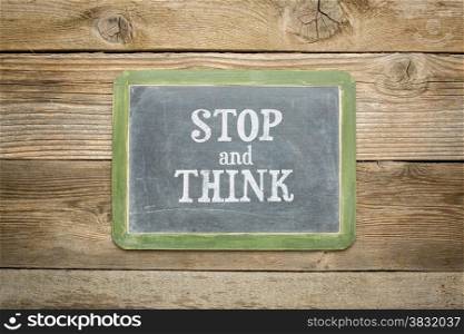 stop and think text on a slate blackboard against rustic weathered wood planks