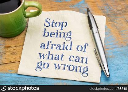 Stop being afraid of what can go wrong - handwriting on a napkin with a cup of coffee