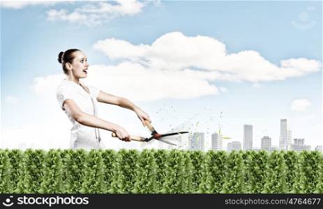 Stop pollution. Young attractive businesswoman cutting green lawn. Greenery concept