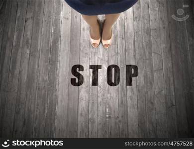 Stop right here. Top view of businesswoman feet and stop sign