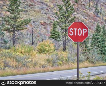 stop sign on a mountain highway in fall scenery - Poudre Canyon in northern Colorado