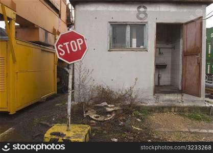 Stop sign outside run down outdoor lavatory