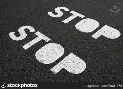 stop signs painted on a asphalt road surface