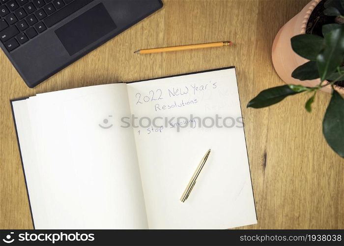 Stop smoking New year&rsquo;s resolution writing down on notebook. Goals for 2022 top view with copy space space for text. Stop smoking New year&rsquo;s resolution writing down on notebook. Goals for 2022 top view with copy space