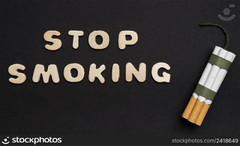 stop smoking text with bunch cigarette arranged black background