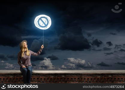 Stop symbol. Young woman in casual holding balloon with prohibition sign