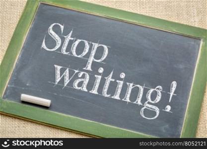 stop waiting advice on a vintage slate blackboard with a white chalk against burlap canvas