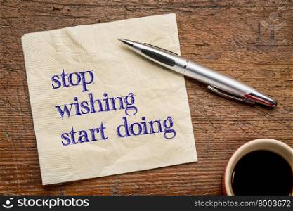 stop wishing, start doing - motivational text on a napkin against grunge wood grunge wood table, top view with coffee