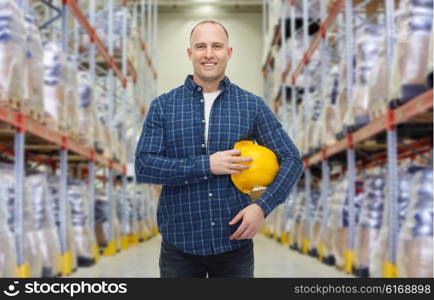 storage, shipment, logistic business, people and export concept - happy man with hardhat over warehouse background