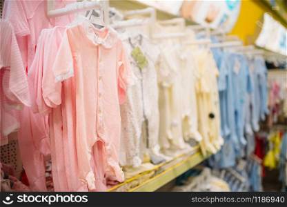 Store for newborns, sliders in cloth department, nobody. Baby wear in shop of goods for infants