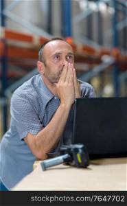 store incharge using a laptop in a warehouse