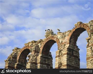 Stork nest on top of an aqueduct of origin of the Roman Hispanic era, located southwest of Spain