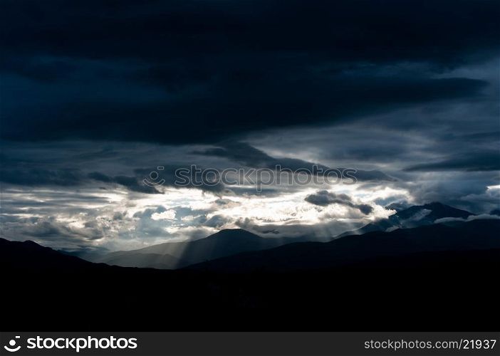 Storm and sun rays over mountains