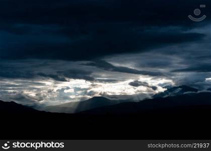 Storm and sun rays over mountains