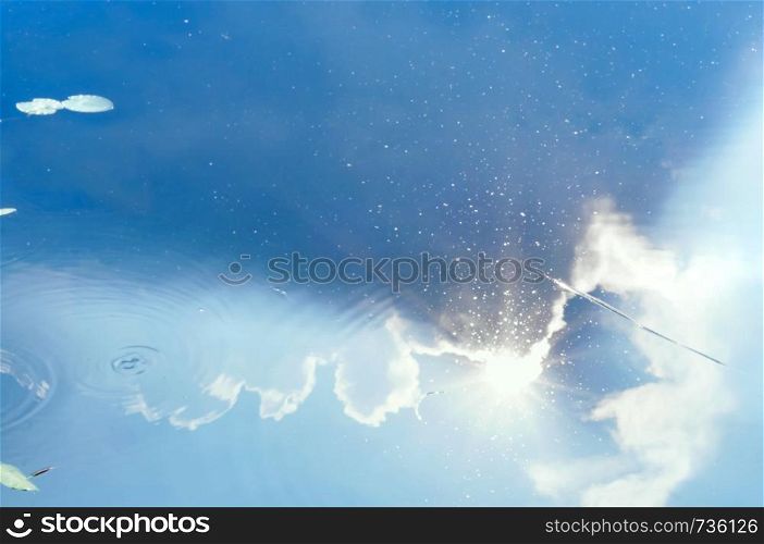 storm clouds cover the sun, the sun and clouds are reflected in the water. the sun and clouds are reflected in the water, storm clouds cover the sun