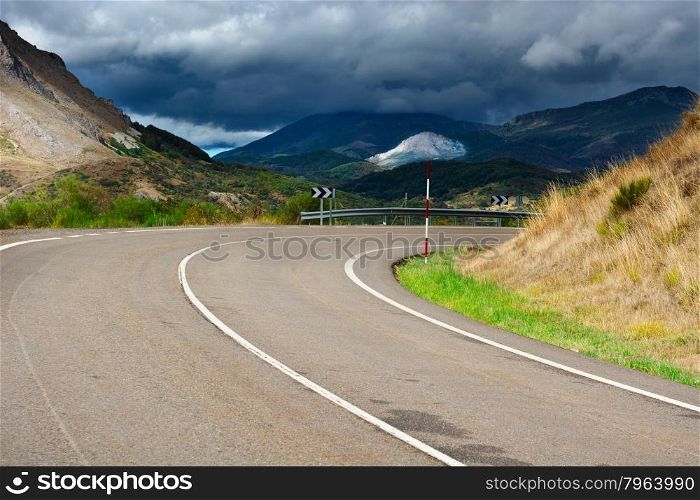 Storm Clouds over the Winding Asphalt Road in the Cantabrian Mountains, Spain