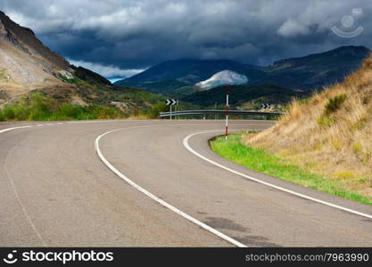 Storm Clouds over the Winding Asphalt Road in the Cantabrian Mountains, Spain